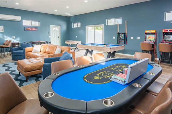 Game room with poker table, foosball, and lounge seating in a Scottsdale short-term rental managed by Arizona STR Management.